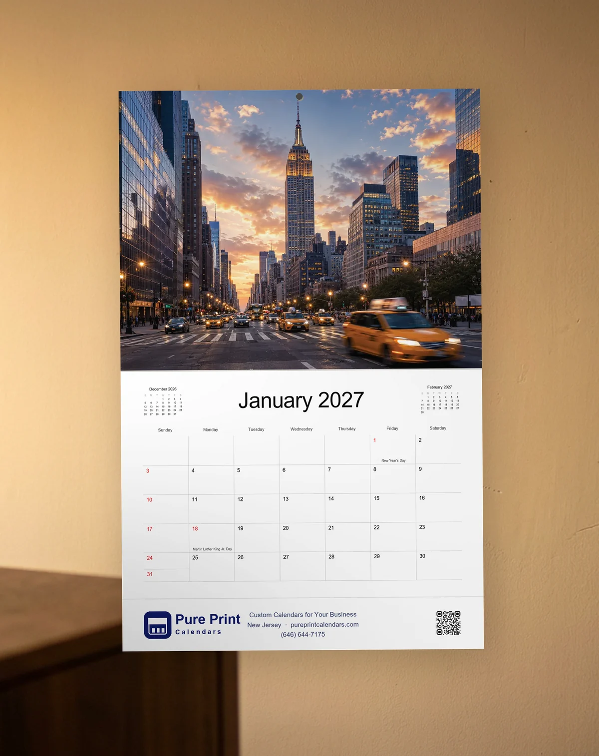 New York 2027 calendar open to January, hanging on a wall